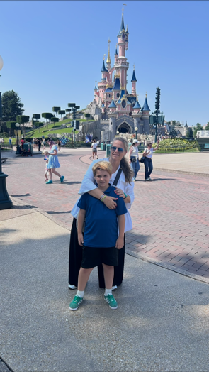 Merce con su hijo frente al castillo de Disneyland Paris