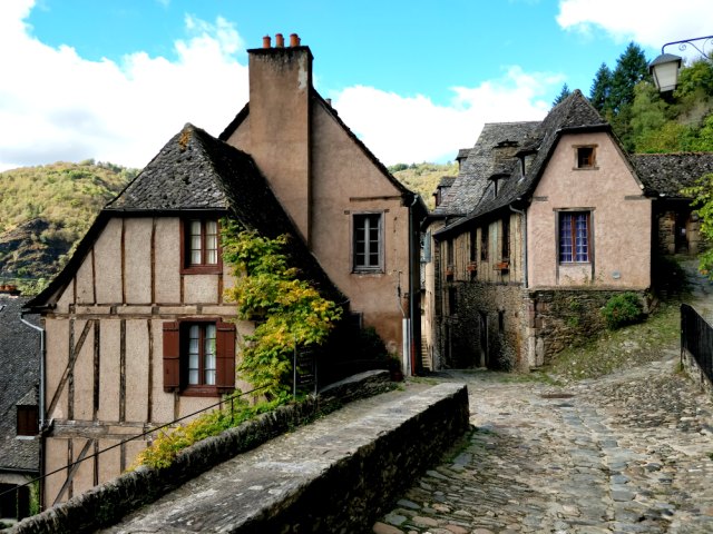 Calle empedrada y casas con entramado de madera en Conques